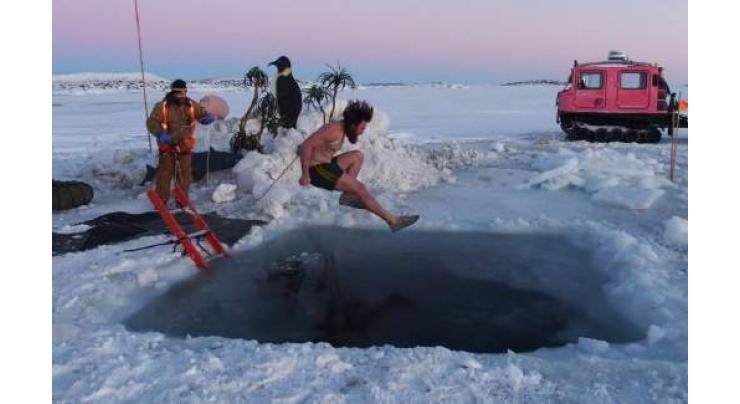 Antarctic researchers mark winter solstice with icy plunge
