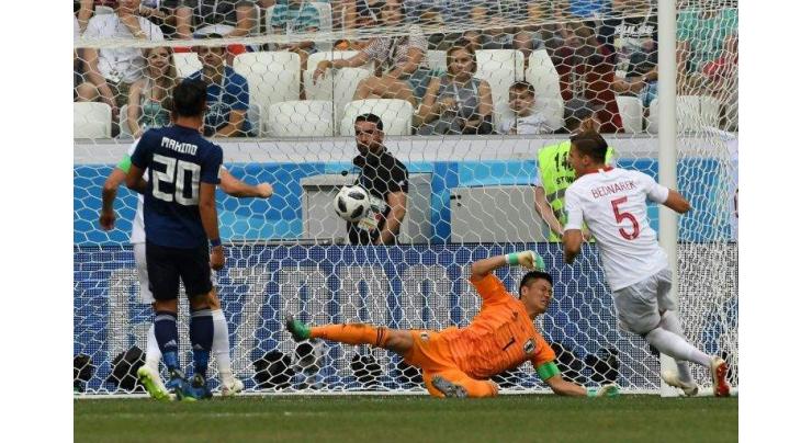 Japan booed off but reach last 16 despite Poland loss
