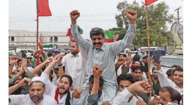 PTI workers jubilant, distribute sweets
