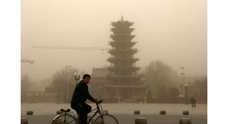Northwest China hit by sandstorm as Beijing is smothered in smog
