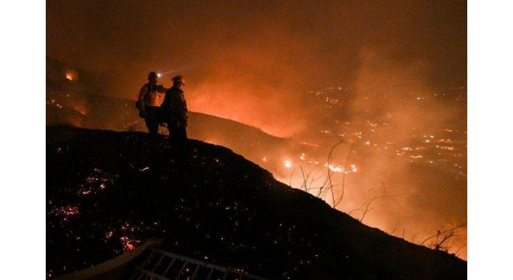 Thousands flee homes near LA as wildfires rage
