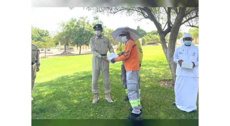 Dubai Police, Spirit of the Union Volunteers distribute meals, 100 umbrella hats to workers