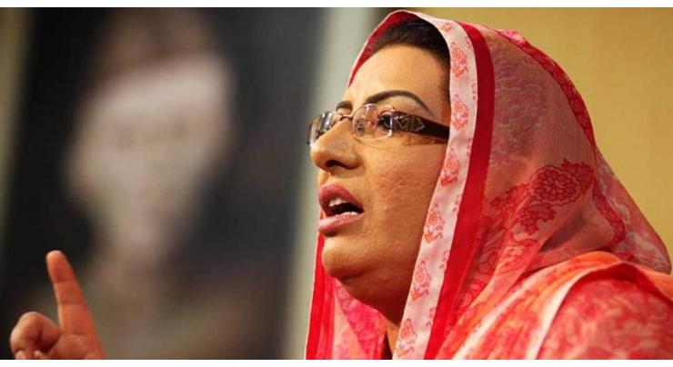People chant slogans in front of Firdous Ashiq Awan