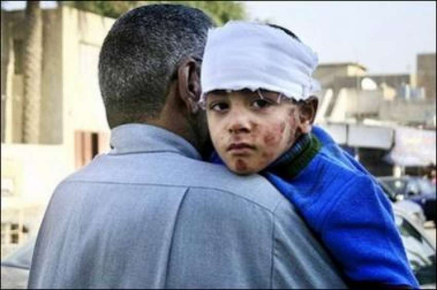 عراق،بم دھماکے میں زخمی ایک بچے کو اس کا والد طبی امداد کے ..