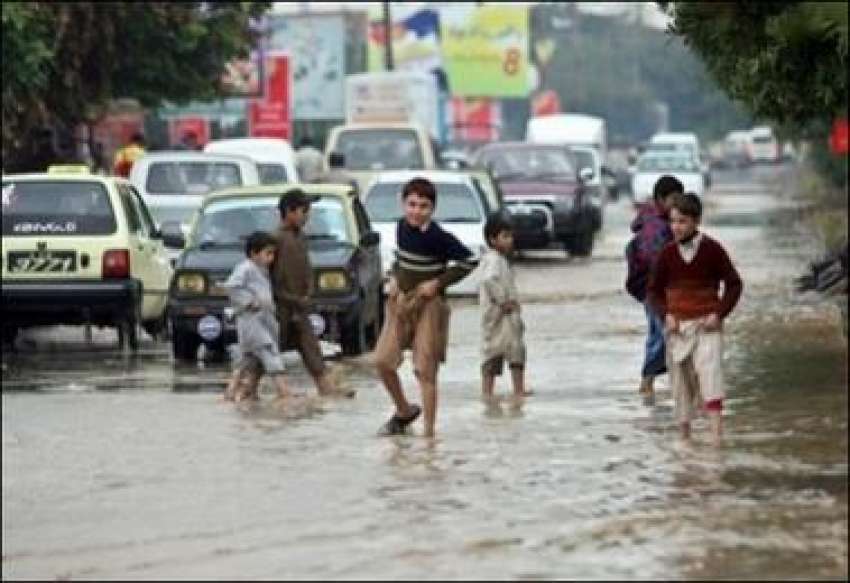راولپنڈی، کرکٹ سٹیڈیم کے باہر بارش کے ہانی میں بچے کھیل ..