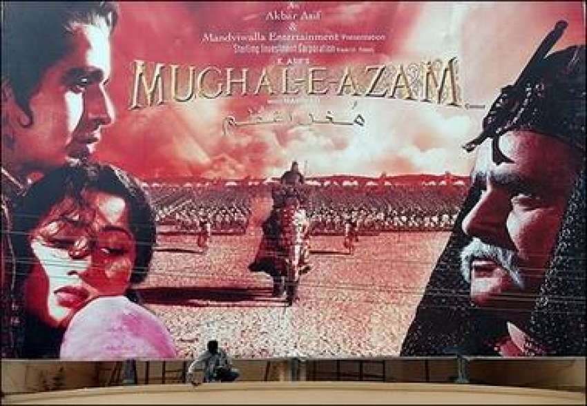 کراچی، ایک سنیما کے باہر مزدور فلم مغل اعظم کے بورڈ کی صفائی ..