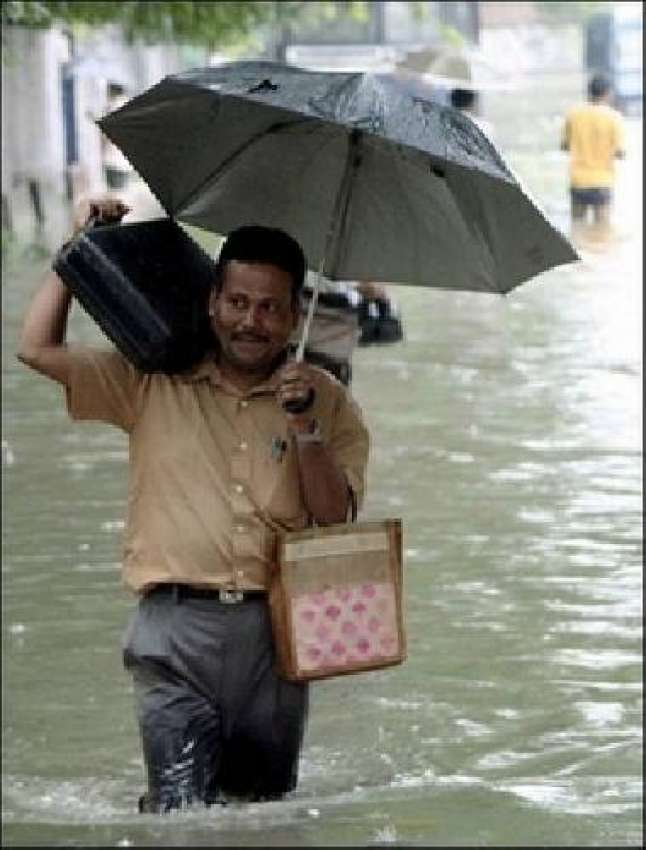 کلکتہ،شدید بارش کے بعد ایک بھارتی اپنا بریف کیس کاندھے پر ..