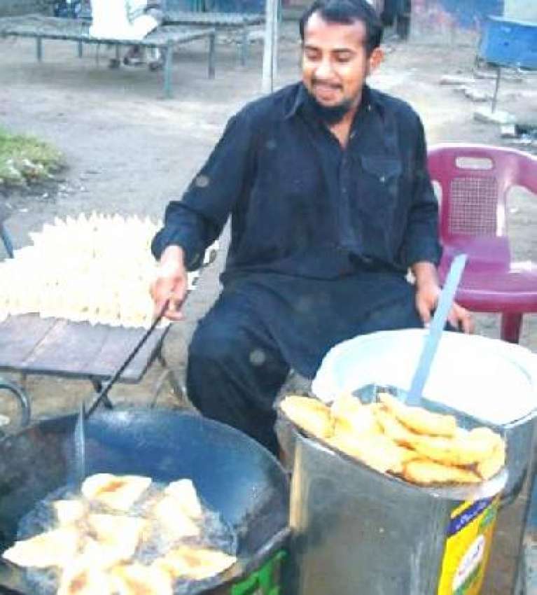 لاہور، افطاری کے لئے ایک دوکاندار سموسے تیار کررہا ہے۔