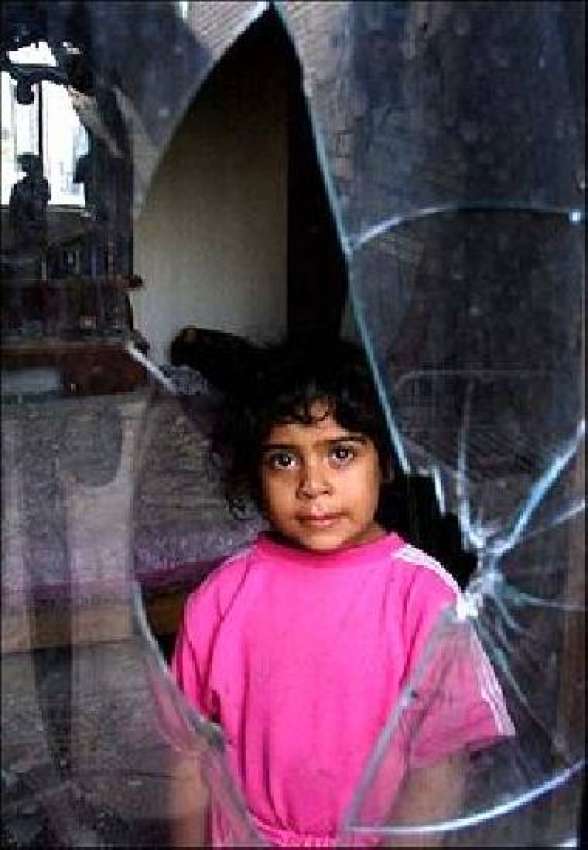 ایک عراقی بچی امریکی حملے میں ٹوٹنے والی اپنے گھر کی کھڑکی ..