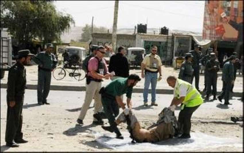 کابل، امدادی کارکن خود کش حملہ‌ آور کی لاش سڑک سے اٹھا رہے ..