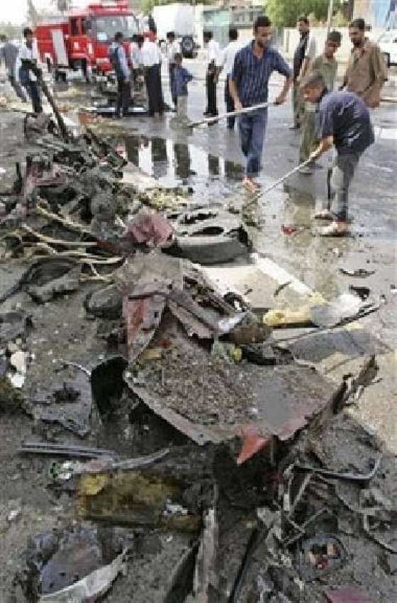 بغداد، مقامی عراقی شہری بم دھماکے میں تباہ ہونے والی گاڑی ..