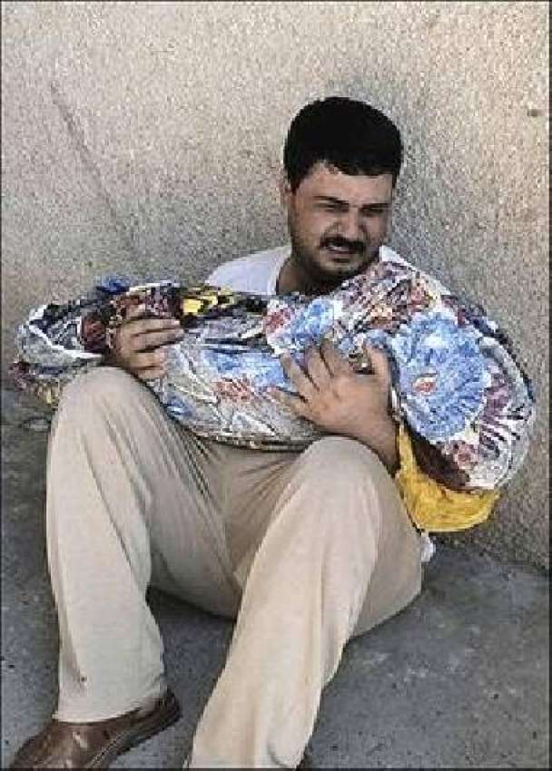 بغداد، ایک عراقی شہری اپنے بیٹے کی لاش گود میں اٹھائے رو ..