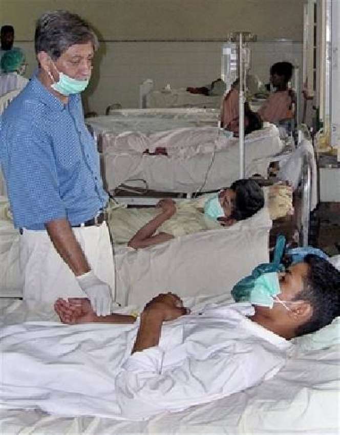 کراچی، ایک ڈاکٹر ڈینگو وائرس سے متاثرہ مریض کا معائنہ کر ..