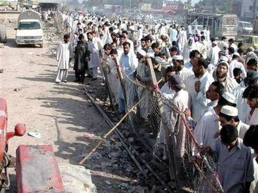 پشاور، بم دھماکے کی جگہ کے قریب مقامی شہری سوگوار کھڑے ہیں۔