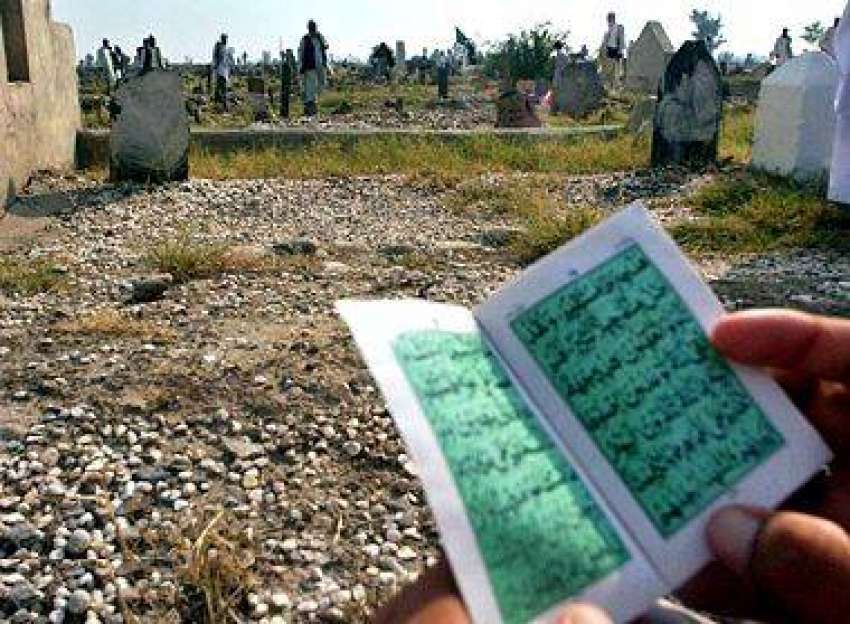پشاور، عید کے دن ایک شخص اپنے رشتہ داروں‌کی  قبروں کے قریب ..