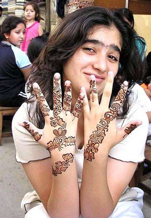 کراچی، ایک لڑکی اپنے ہاتھوں پر لگی مہندی کے ڈیزائن دکھاتے ..