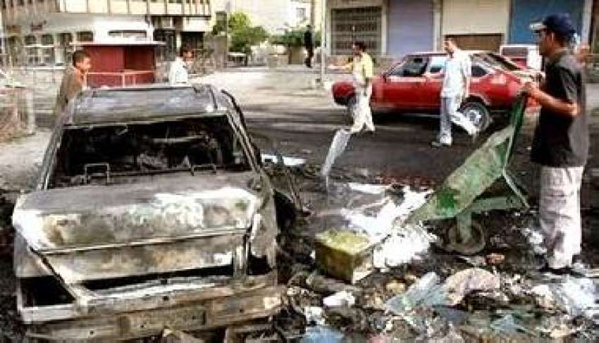 بغداد،کار بم دھماکے کا ملبہ، عراقی شہری اکٹھا کرتے ہوئے۔ ..