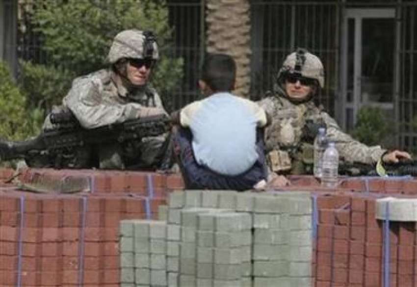 بغداد، ایک عراقی بچہ امریکی فوجیوں کو گشت کرتا دیکھ رہاہے۔