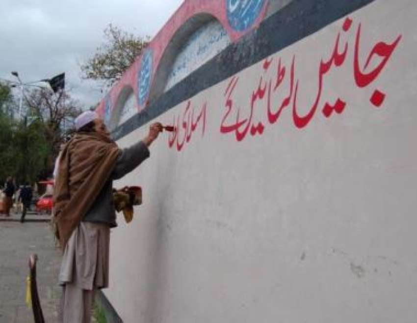 اسلام آباد، ایک طالبعلم لال مسجد کی دیوار پر نعرے لکھ رہا ..