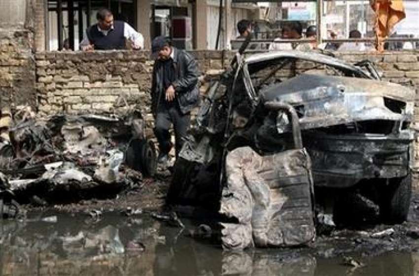 بغداد،پولیس اہلکار بم دھماکے کے بعد جائے وقوعہ کا معائنہ ..