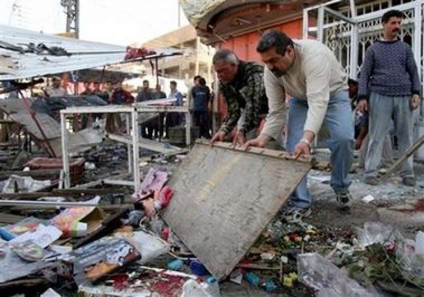 بغداد،عراقی شہری مارکیٹ میں‌کار بم دھماکے کے بعد جگہ کی ..