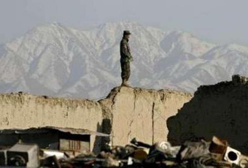 کابل،ایک افغان فوجی تباہ ہونیوالے گھر کی چھت پر کھڑا پہرا ..