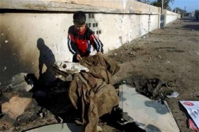 بغداد،ایک عراقی بچہ بم دھماکے میں تباہ ہونیوالی عراقی فوجیوں‌کی ..
