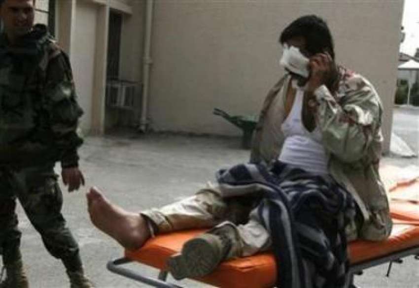 بغداد،ایک زخمی عراقی فوجی طبی امداد کے بعد موبائل پر بات ..