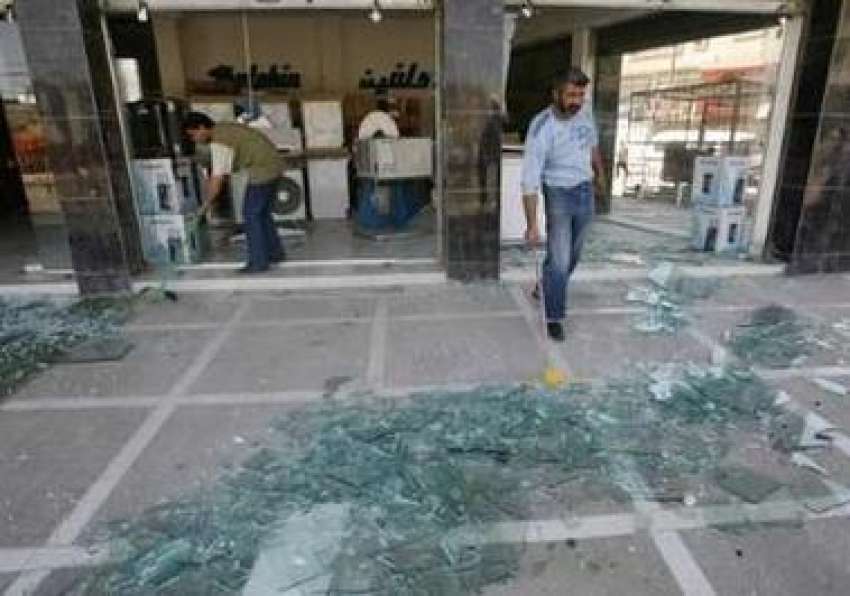بغداد،کار بم دھماکے کے بعد عراقی شہری اپنی دکانوں سے ٹوٹے ..