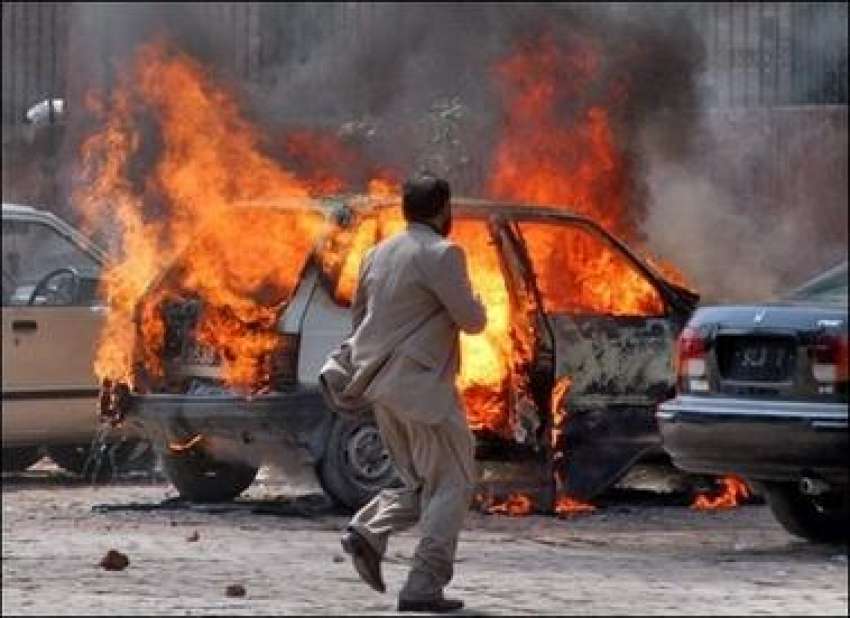 لاہور، پولیس کی شیلنگ سے ایک گاڑی کو آگ لگی ہوئی ہے۔