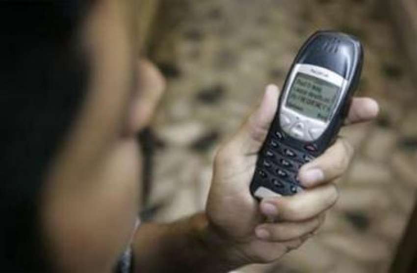 کراچی،ایک شخص موبائل پر موصول ہونیوالا پیغام پڑھ رہا ہے،ملک ..