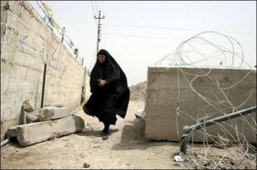 بغداد،عراقی خاتون کنکریٹ کی دیوار کے پاس سے گزر رہی ہے ،جو ..