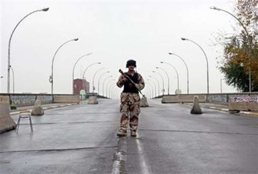 بغداد،عراقی سکیورٹی اہلکارچیک پوسٹ پرالرٹ کھڑا ہے۔