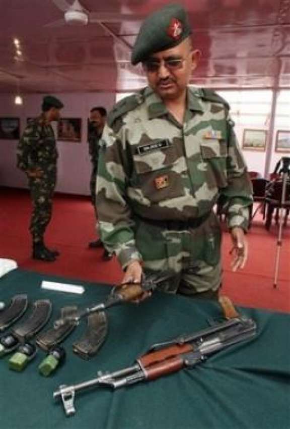 سرینگر، بھارتی فوج کا ایک افسر صحافیوں کو اسلحہ دکھا رہا ..