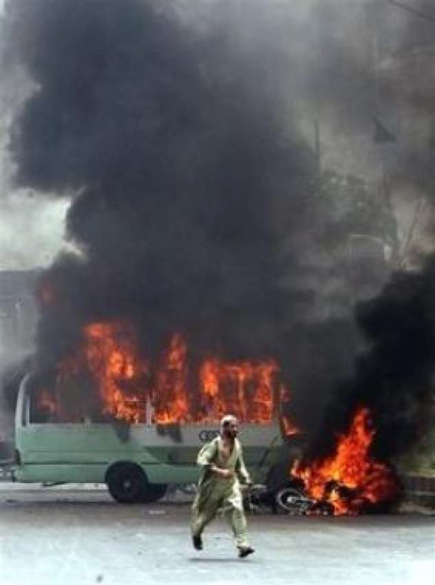 کراچی، مظاہرین کی طرف سے نذر آتش کی گئی ایک بس سے آگ کے شعلے ..