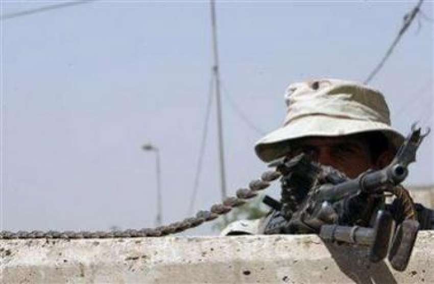 بغداد،عراقی سکیورٹی اہلکاراپنی چیک پوائنٹ پر مشین گن سنبھالے ..