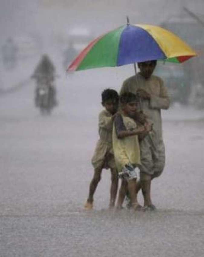 لاہور،شدید بارش میں بچے سڑک پار کر رہے ہیں۔