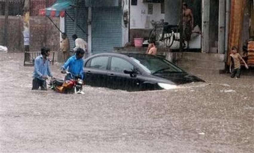 لاہور،شدید بارش سے پانی کھڑاہو جانے کی وجہ سے ایک گاڑی پانی ..