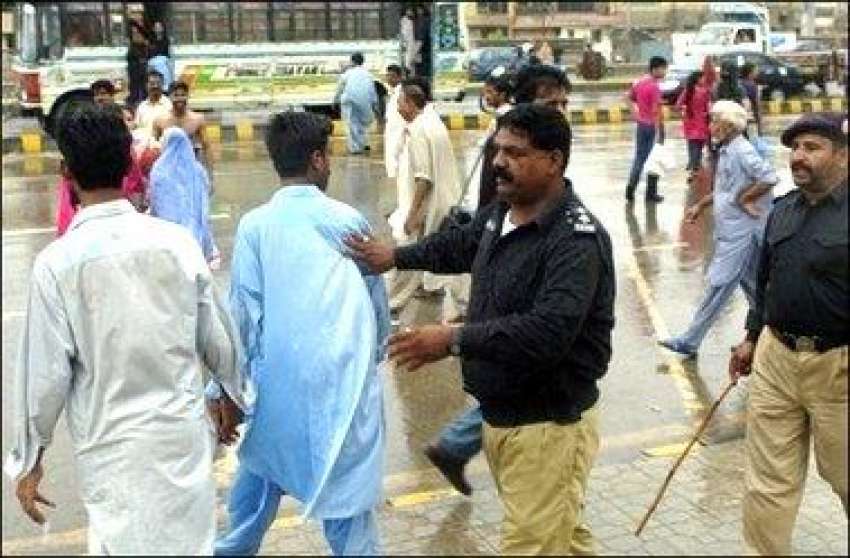 کراچی، پولیس اہلکار مقامی لوگوں کو ساحل سمندر کی طرف جانے ..