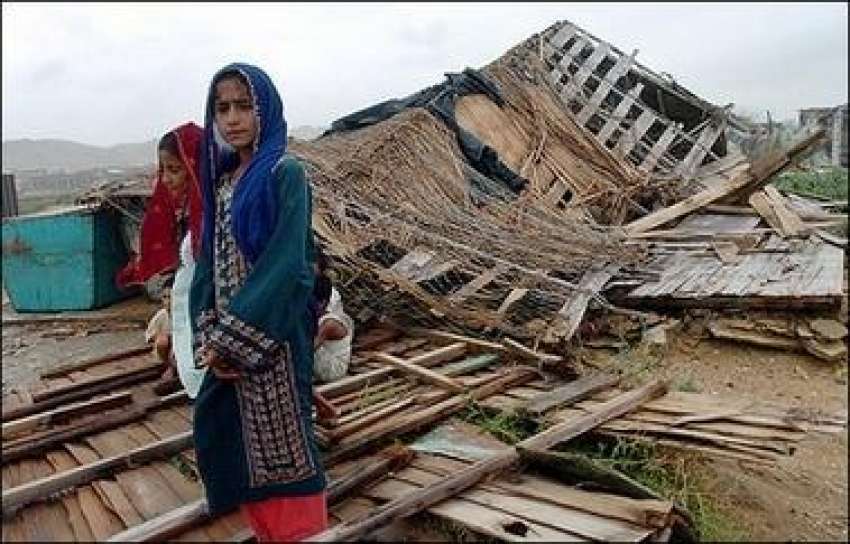 کراچی،ایک لڑکی یمین طوفان سے متاثرہ علاقہ میں اپنے تباہ ..
