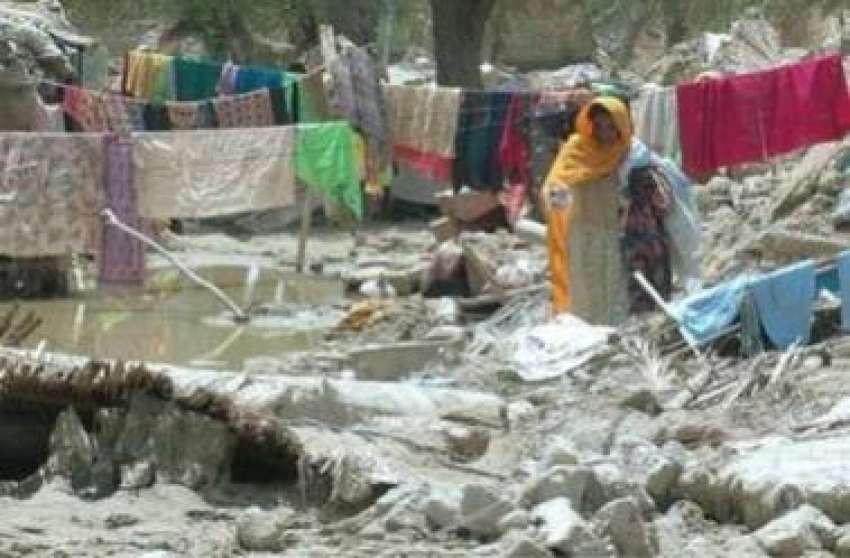 تربت،سیلاب سے متاثرہ ایک خاتون اپنے مکان کے ملبے پر کپڑے ..