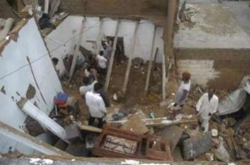کراچی،امدادی اہلکار اس مکان کا ملبہ صاف کر رہے ہیں جس کی ..