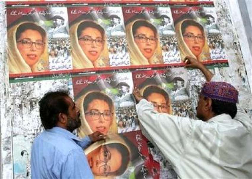 کراچی، پیپلز پارٹی کے کارکن بینظیر بھٹو کی تصاویر والے پوسٹرز ..