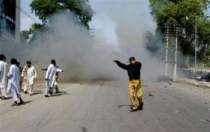 پشاور،پولیس اہلکار بم دھماکے کے بعد شہریوں کو وہاں سے دور ..