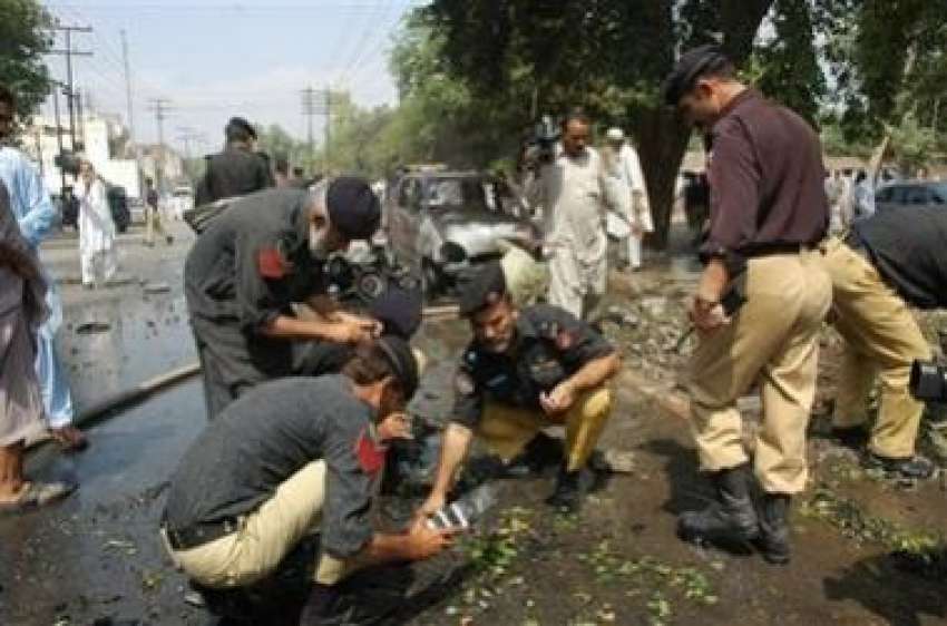 پشاور،پولیس اہلکار بم دھماکے کی جگہ کا معائنہ کر رہے ہیں۔