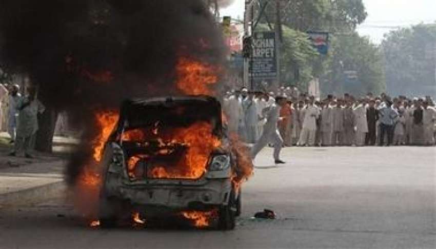 پشاور،بم دھماکے کے بعد ایک گاڑی میں آگ لگی ہوئی ہے۔