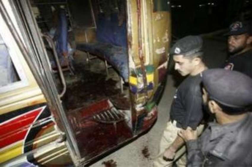 کراچی،پولیس اہلکار اس بس کامعائنہ کر رہے ہیں‌ جس پر نامعلوم ..