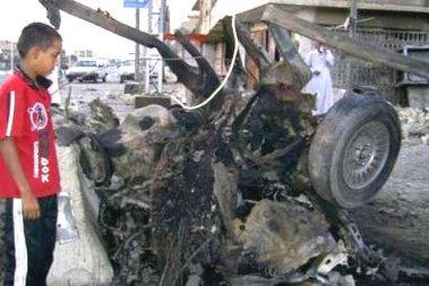 بغداد، ایک عراقی بچہ بم دھماکے میں تباہ ہونے والی گاڑی کا ..