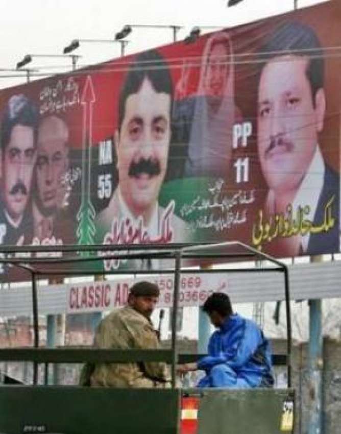 راولپنڈی،فوج کا ایک ٹرک ایک انتخابی بینرکےقریب پیٹرولنگ ..