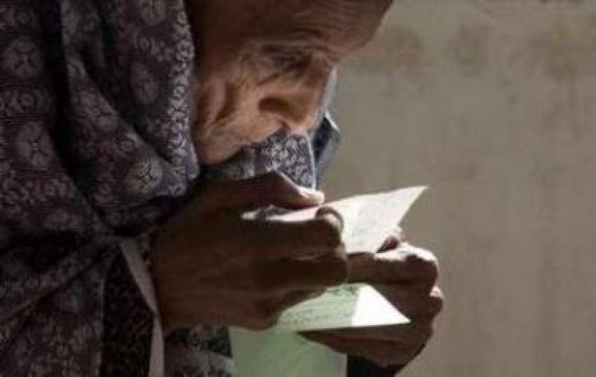 راولپنڈی،ایک بوڑھی خاتون ووٹ ڈالنے سے قبل بیلٹ پیپر غور ..